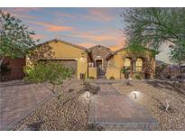Inviting single-story home featuring a paved walkway and beautiful desert landscaping at 45 Moltrasio Ln, Henderson, NV 89011