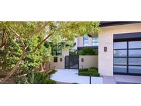 Elegant home featuring lush landscaping, a modern gate, and a contemporary design, creating a welcoming entrance at 4915 Summit Overlook Dr, Las Vegas, NV 89135