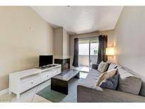 Comfortable living room with a cozy fireplace and sliding glass door to a private balcony at 4200 S Valley View Blvd # 3092, Las Vegas, NV 89103
