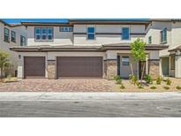 Charming two-story townhome featuring a two-car garage, brick accents, and neutral color palette at 8401 Waterwood St, Las Vegas, NV 89166