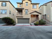 Charming two-story townhome featuring a two-car garage, a balcony, and a landscaped front yard at 4750 Newby Hall Ct, Las Vegas, NV 89130