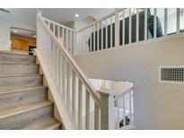 Modern staircase with wood-look flooring and white railings at 4750 Newby Hall Ct, Las Vegas, NV 89130