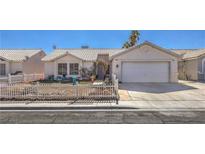 Charming single-story home featuring a white picket fence, desert landscaping, and a two-car garage at 4357 Valley Regal Way, North Las Vegas, NV 89032