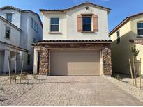 Two-story house with beige exterior, brown garage door, and paved driveway at 655 N Water St, Henderson, NV 89015