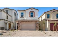 Inviting home featuring a stone-accented two-car garage and neutral stucco exterior, framed by desert landscaping at 655 N Water St, Henderson, NV 89015