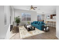 Bright living room featuring a teal sofa and stylish coffee table at 135 Gracious Crest Ave, North Las Vegas, NV 89032