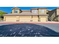 Low angle of building exterior with multi-car garage doors and desert landscaping at 6868 Sky Pointe Dr # 2039, Las Vegas, NV 89131