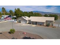 Single-story home with a large yard, flag, and mountain views at 3581 Pahrump Valley Blvd, Pahrump, NV 89048