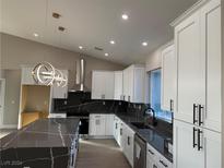 Modern kitchen with white cabinets, large island, and dark countertops at 3060 Spy Glass Ave, Pahrump, NV 89048