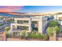 Modern two-story home featuring a balcony, large windows, and a beautifully landscaped yard, nestled within a vibrant community at 28 Rainbow Point Pl, Henderson, NV 89011