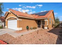 Tan one-story house with solar panels, tile roof, and a white garage door at 6370 Canyon Vista Ct, Las Vegas, NV 89156