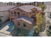 Charming two-story home featuring a tile roof, desert landscaping, and an attached two-car garage at 7125 Mountain Den Ave, Las Vegas, NV 89179