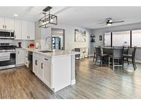 Open concept kitchen and dining area, featuring modern appliances and stylish island at 2801 Willow Wind Ct, Las Vegas, NV 89117