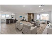 Bright, open-concept living room featuring a stone fireplace and modern finishes at 2368 Winterwood Blvd, Las Vegas, NV 89142