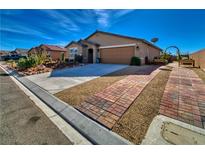 Charming home featuring desert landscaping, a brick-paved driveway, and a well-maintained front yard at 3573 E Garfield Dr, Pahrump, NV 89061