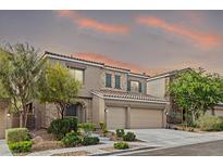 Beautiful two-story home with a stone facade, desert landscaping, and a two-car garage at sunset at 9143 Irish Elk Ave, Las Vegas, NV 89149
