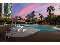 Stunning outdoor pool area featuring lounge chairs, palm trees, and architectural rock features at 222 Karen Ave # 808, Las Vegas, NV 89109