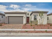 Charming single-story home with a brick driveway and well-maintained landscaping at 853 Bittern Lake St, Henderson, NV 89011