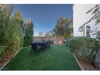 Inviting backyard with artificial turf, a dining set, and privacy landscaping creates a perfect outdoor gathering space at 3368 Epson St, Las Vegas, NV 89129