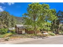 Mountain cabin exterior with large tree and paved road at 3968 Mont Blanc Way, Las Vegas, NV 89124