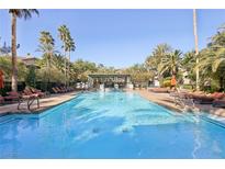 Inviting community pool with lounge chairs and a shaded seating area at 8737 Red Brook Dr # 103, Las Vegas, NV 89128