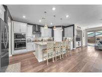 Modern kitchen features white cabinets, granite countertops, stainless steel appliances, and breakfast bar seating at 2043 Arrington Ave, North Las Vegas, NV 89086