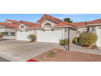 Home with multiple garages with white doors and a red tiled roof at 7814 Ravenhollow Ln, Las Vegas, NV 89145