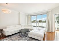 Bright living room with a white leather couch, hardwood floors and access to a balcony at 322 Karen Ave # 206, Las Vegas, NV 89109