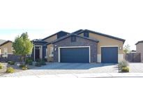 Charming home featuring a stone facade, two-car garage, and manicured front yard at 7047 Noble Flair Ct, Las Vegas, NV 89131