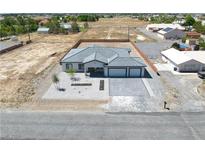 Aerial view of a single-story house with a three-car garage and landscaped yard at 1691 Blackhorn St, Pahrump, NV 89048