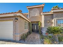 Two-story house with stucco exterior, tile roof, and landscaped walkway at 5205 Sandy Cactus Ln, Las Vegas, NV 89149