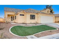 One-story house with tan exterior, landscaped lawn, and attached garage at 6143 Basilone Ave, Las Vegas, NV 89122