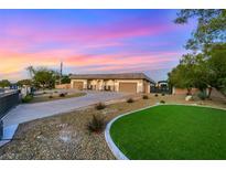 Single story home with large garage, desert landscaping, and green grass at 647 Foxhall Rd, Henderson, NV 89002