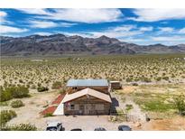 Aerial view of a log home on a large desert lot with mountain views at 561 Miranda Rd, Pahrump, NV 89060