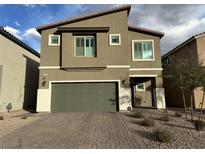 Inviting two-story home with neutral exterior, green garage door and brick driveway at 7156 Woodrow Ranch St, Las Vegas, NV 89166