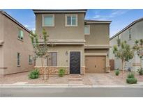 Tan two-story home with a brown door and garage door, landscaping, and a paved driveway at 5266 Sherwood Forest Ln, Las Vegas, NV 89122