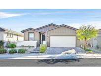 Inviting single-story home features a well-manicured yard, brick driveway, and attached two-car garage at 2383 Elmont Ave, North Las Vegas, NV 89086