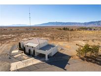 Aerial view of two story house with attached garage, and expansive desert landscape at 3490 S Adobe Ct, Pahrump, NV 89048