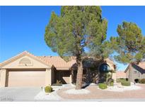 One-story house with tan exterior, tile roof, and landscaped front yard at 9904 Arbuckle Dr, Las Vegas, NV 89134