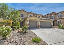Inviting two-story home features a three-car garage and desert landscaping in the front yard at 3605 Sapphire Sea Ct, North Las Vegas, NV 89031