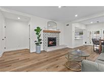 Bright living room with fireplace, hardwood floors, and a stylish glass coffee table at 2628 Starfish Ct, Las Vegas, NV 89128