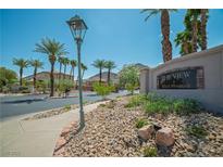 Community entrance with palm trees, lush landscaping, and clear blue skies on a sunny day at 716 Solitude Point Ave, Henderson, NV 89012