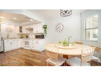 Bright kitchen features white cabinets, granite counters, and a dining area at 7944 Diamond Rock Way # 202, Las Vegas, NV 89128
