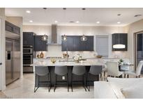 Modern kitchen featuring gray cabinets, stainless steel appliances, pendant lighting, and a spacious island with bar seating at 2781 Josephine Dr, Henderson, NV 89044