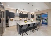 A modern kitchen features an island with barstool seating and stainless steel appliances at 2781 Josephine Dr, Henderson, NV 89044