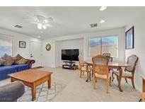 Comfortable living room featuring a ceiling fan, bright natural light, and space for dining at 6058 Ambleshire Ave, Las Vegas, NV 89139