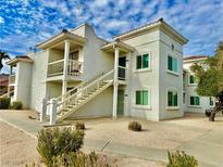 Two-story condo building with white exterior and stairs at 1904 Las Palmas Ln # 203, Laughlin, NV 89029