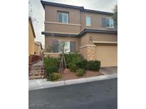 Two-story house with tan exterior, attached garage, and landscaped front yard at 10753 Cather Ave, Las Vegas, NV 89166