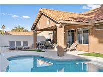 Backyard pool featuring lounge chairs, covered patio, and lush landscaping for outdoor entertaining at 175 Enloe St, Henderson, NV 89074