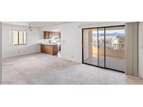 Bright living room featuring a sliding glass door to a balcony and an adjacent kitchen with tiled floor at 1965 Scimitar Dr # 0, Henderson, NV 89014